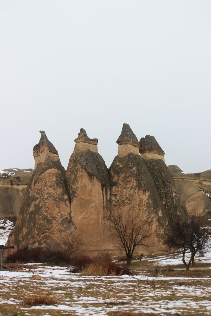 Beautiful rock formations known as fairy chimneys in snowy Cappadocia, Turkey.